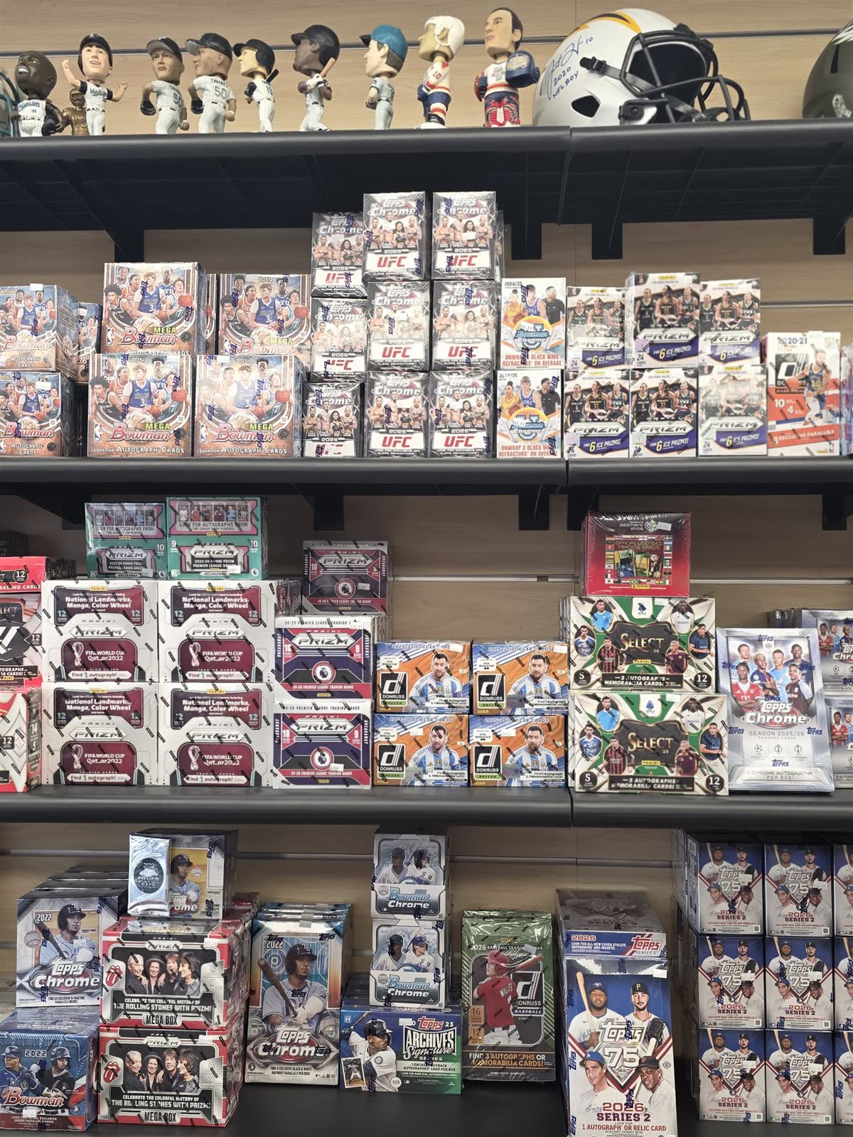 The sports wall at GG Hobby — helmets, bobbleheads and hobby boxes
