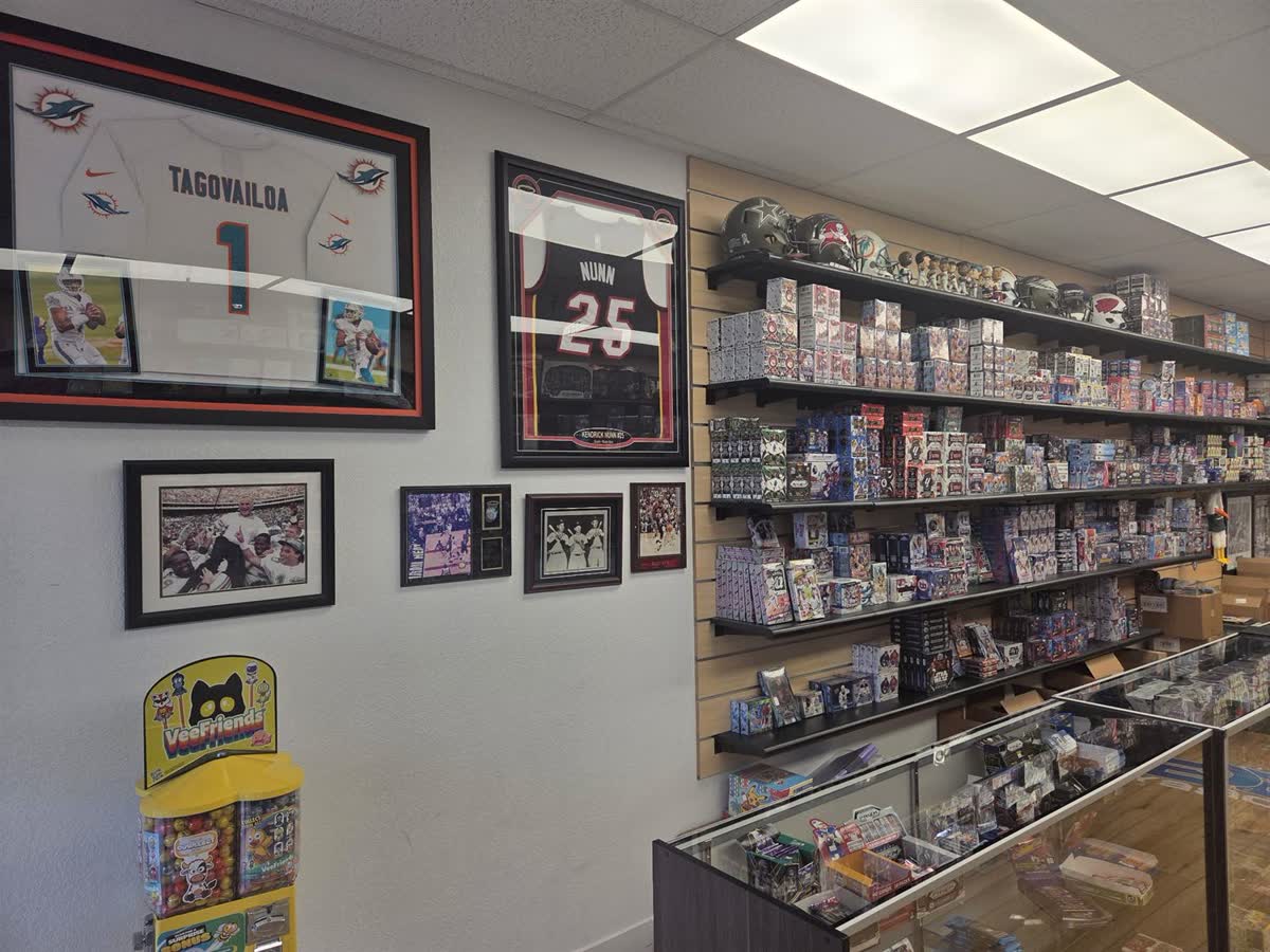 The memorabilia wall at GG Hobby — signed Tagovailoa jersey, framed jerseys and helmets